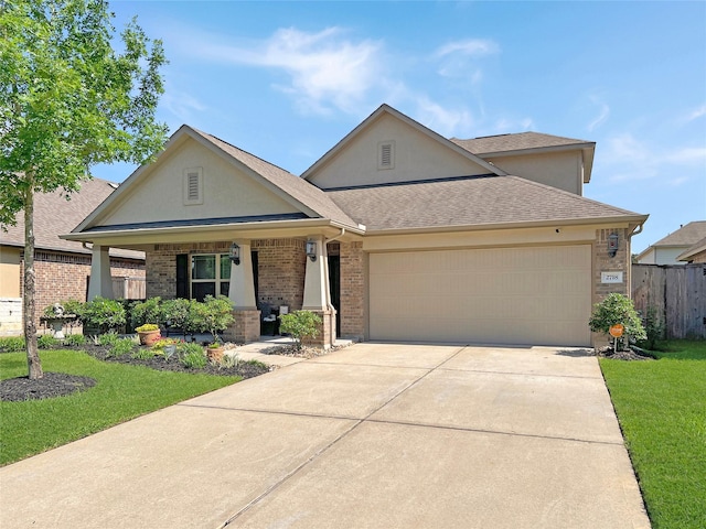 view of front of home featuring covered porch, brick siding, a front lawn, an attached garage, and stucco siding
