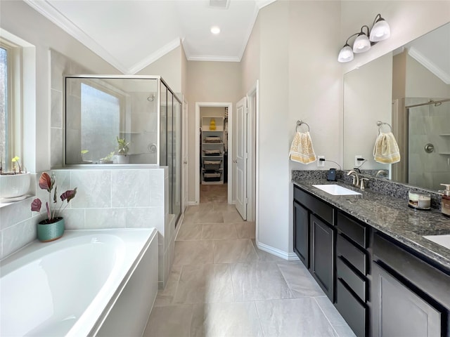 bathroom with crown molding, a walk in closet, a sink, a shower stall, and a garden tub