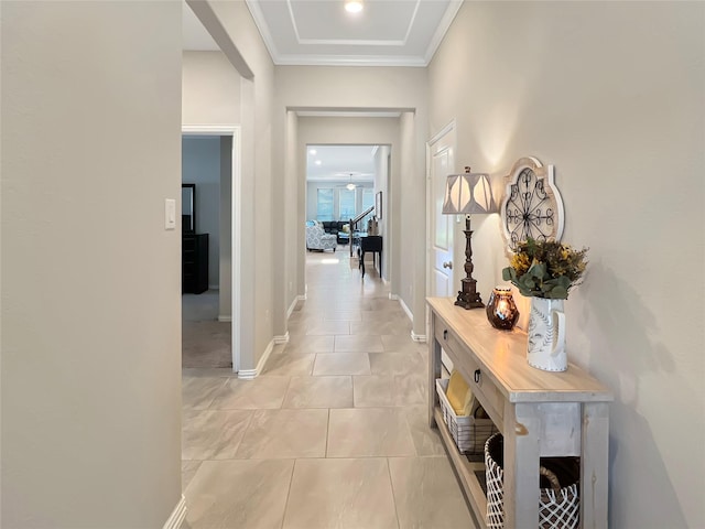 hall featuring light tile patterned floors, baseboards, and ornamental molding