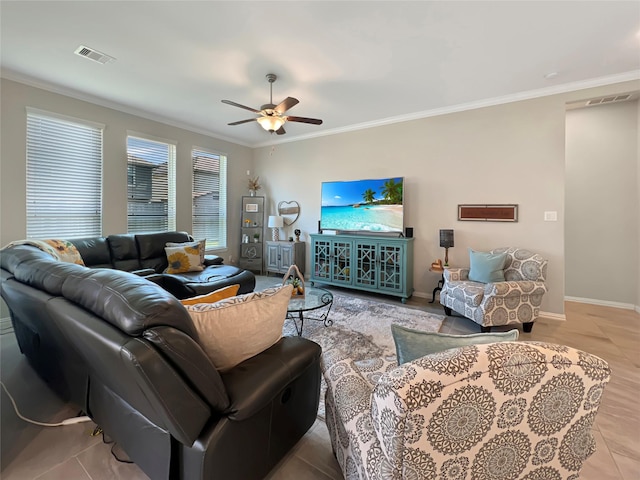 living room featuring crown molding, baseboards, a ceiling fan, and visible vents