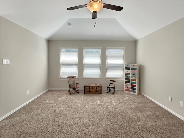 living area featuring a healthy amount of sunlight, carpet, a ceiling fan, and vaulted ceiling