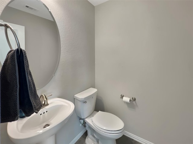 bathroom featuring visible vents, a sink, baseboards, and toilet