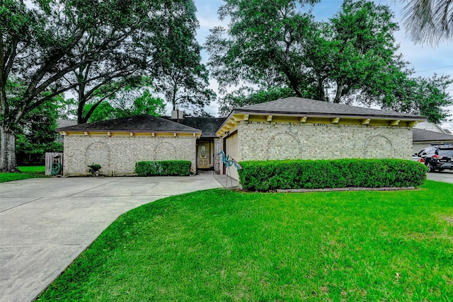 view of front facade with an attached garage, a front yard, and concrete driveway