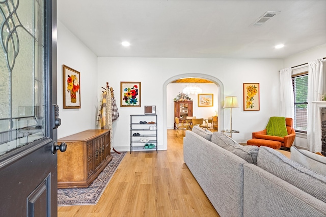 living area with visible vents, arched walkways, baseboards, recessed lighting, and light wood-style flooring