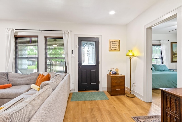foyer featuring baseboards, recessed lighting, light wood finished floors, and a wealth of natural light