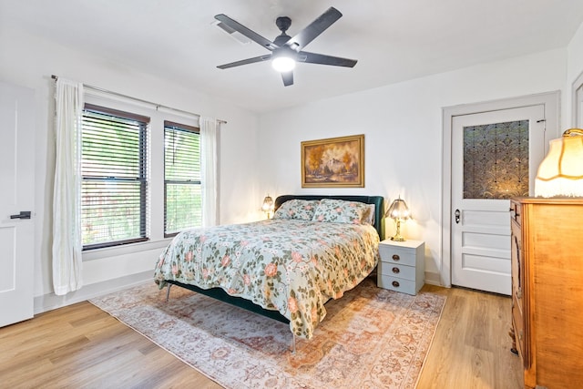 bedroom with a ceiling fan, baseboards, and light wood-style floors
