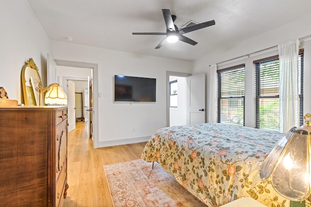 bedroom with light wood-style floors, baseboards, a ceiling fan, and visible vents