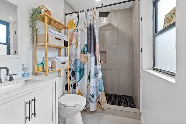 full bath featuring vanity, a tile shower, and toilet