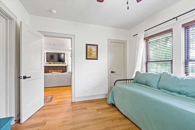 bedroom featuring baseboards, a ceiling fan, and light wood-style flooring