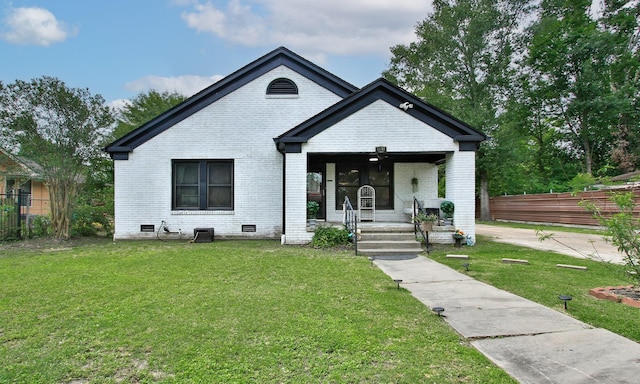 bungalow-style house featuring covered porch, brick siding, fence, and a front yard