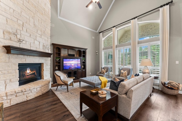 living area featuring a fireplace, ceiling fan, dark wood-style floors, high vaulted ceiling, and plenty of natural light