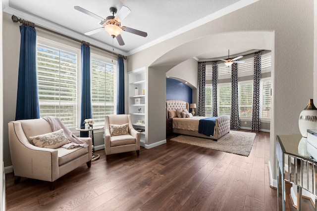 bedroom with ornamental molding, hardwood / wood-style floors, baseboards, arched walkways, and a ceiling fan