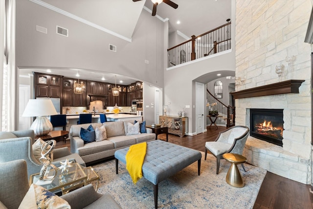 living area with high vaulted ceiling, a ceiling fan, stairs, and visible vents