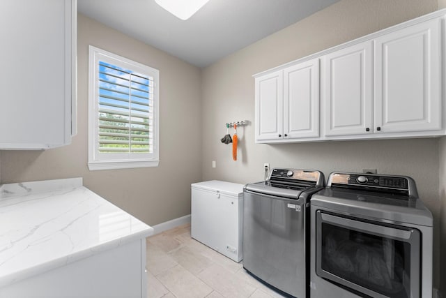 clothes washing area with cabinet space, baseboards, and washer and dryer