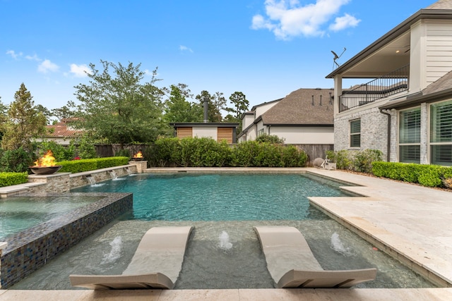 view of pool featuring a patio, a fenced backyard, and a pool with connected hot tub