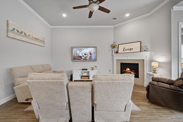 4381 Victoria Pine Dr, Spring, TX 77386 - dining area with a ceiling fan, wood finished floors, a tiled fireplace, ornamental molding, and recessed lighting