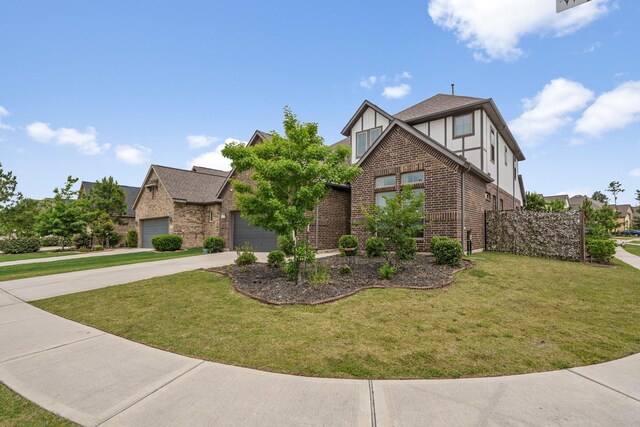 4381 Victoria Pine Dr, Spring, TX 77386 - tudor home with brick siding, concrete driveway, a front yard, a garage, and stucco siding