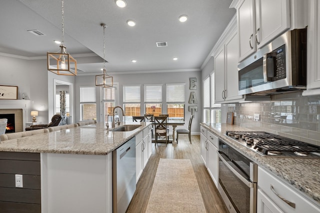 4381 Victoria Pine Dr, Spring, TX 77386 - kitchen with a sink, appliances with stainless steel finishes, crown molding, decorative backsplash, and white cabinetry