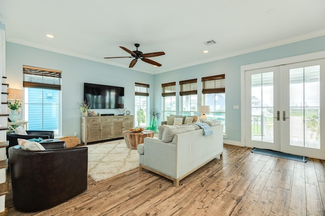 living area with ornamental molding, wood finished floors, and visible vents
