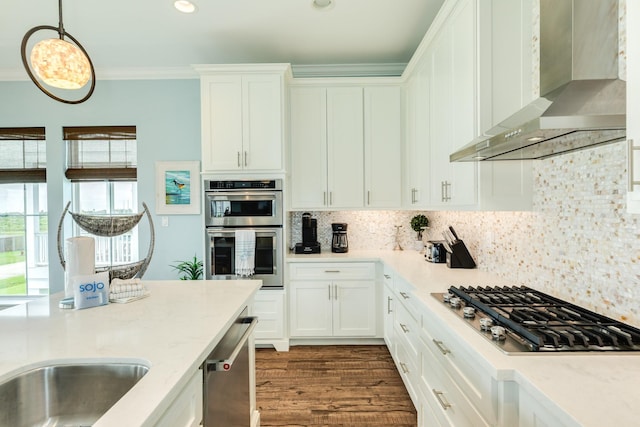 kitchen featuring stainless steel appliances, white cabinetry, a wealth of natural light, and wall chimney exhaust hood
