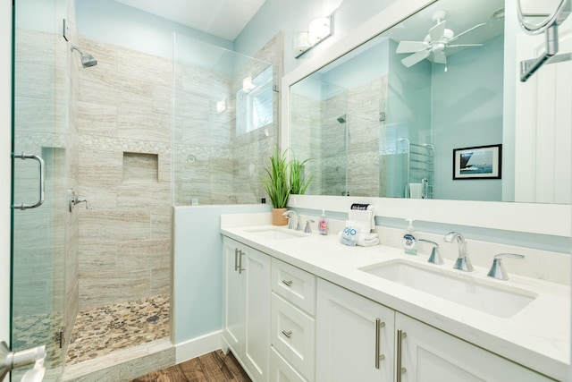 full bathroom with a sink, ceiling fan, a stall shower, and wood finished floors