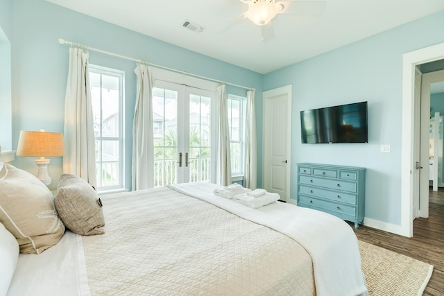 bedroom with baseboards, multiple windows, wood finished floors, and visible vents