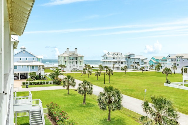 view of property's community featuring a lawn, a water view, and a residential view
