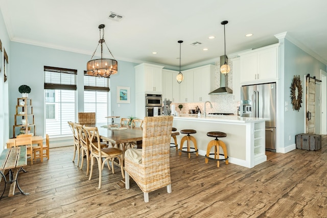 dining room with crown molding, recessed lighting, visible vents, and light wood-type flooring