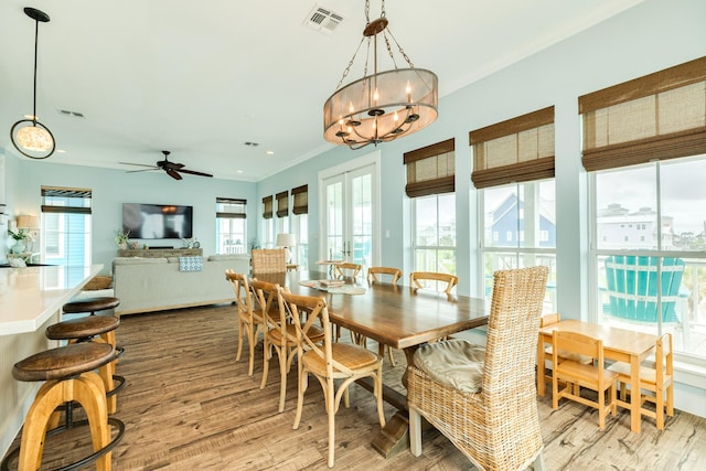 dining room with visible vents, ceiling fan with notable chandelier, and light wood-type flooring