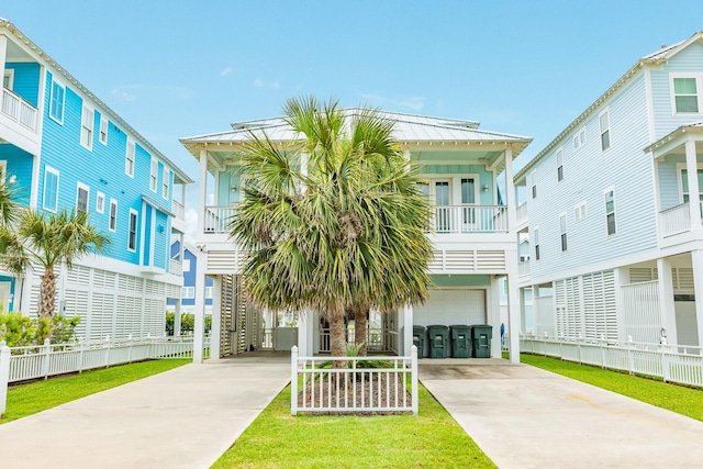 beach home with metal roof, a garage, driveway, and a standing seam roof