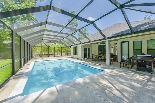 pool with outdoor dining area, ceiling fan, a patio area, and glass enclosure