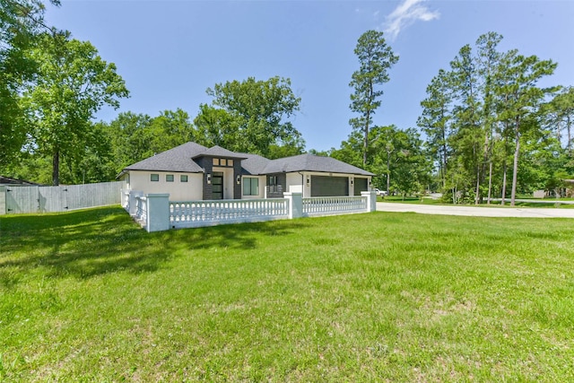 view of front of house featuring stucco siding, a fenced front yard, roof with shingles, and a front lawn