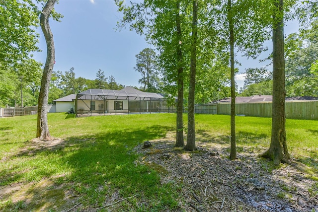 view of yard featuring a fenced backyard and a lanai