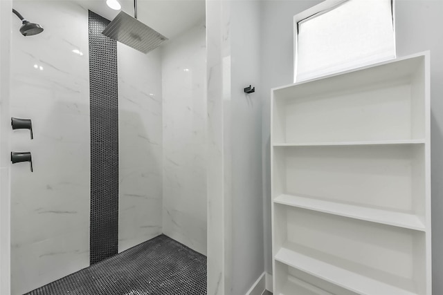 bathroom featuring a marble finish shower