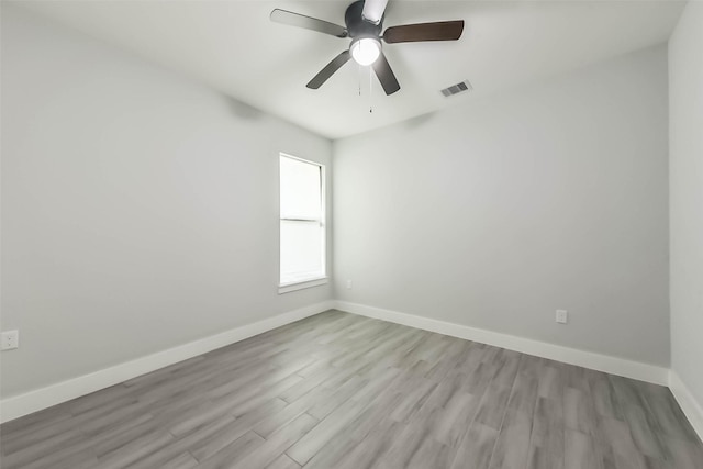 spare room featuring baseboards, visible vents, ceiling fan, and light wood-type flooring