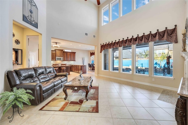28202 Rippling Brook Ln, Fulshear, TX 77441 - living area featuring ceiling fan, visible vents, baseboards, a high ceiling, and light tile patterned flooring