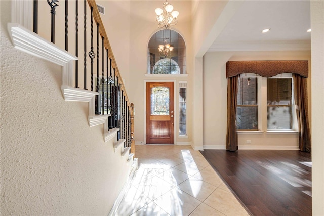 28202 Rippling Brook Ln, Fulshear, TX 77441 - tiled foyer featuring an inviting chandelier, crown molding, visible vents, baseboards, and stairway