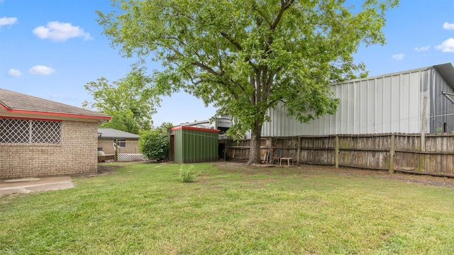view of yard with fence and an outdoor structure