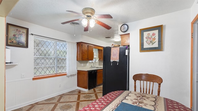 kitchen with a ceiling fan, light countertops, a textured ceiling, a sink, and black appliances