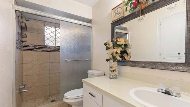 bathroom with toilet, a shower stall, and vanity