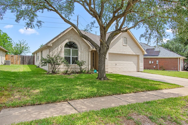 view of front of house with driveway, a front yard, brick siding, fence, and an attached garage