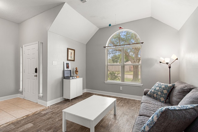 living room featuring plenty of natural light, vaulted ceiling, and wood finished floors
