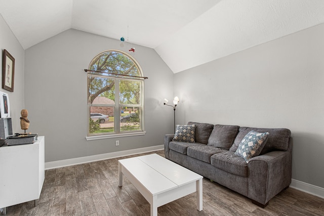 living area with plenty of natural light, baseboards, lofted ceiling, and wood finished floors