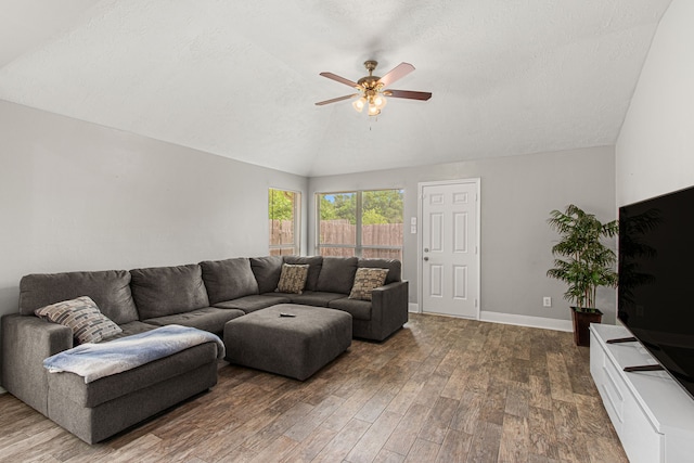 living area featuring baseboards, ceiling fan, vaulted ceiling, and wood finished floors