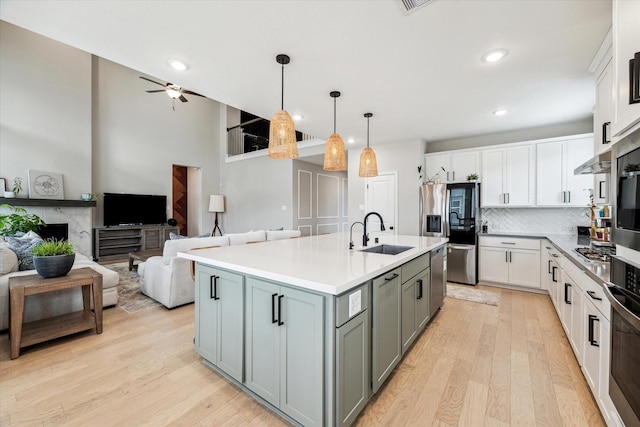 kitchen with a sink, light wood-style floors, stainless steel appliances, recessed lighting, and white cabinetry
