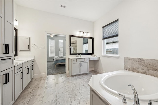bathroom with visible vents, baseboards, marble finish floor, and a bath