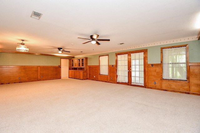 406 Hidden Creek Cir, Sealy, TX 77474 - unfurnished room featuring a wainscoted wall, light carpet, ceiling fan, and wood walls
