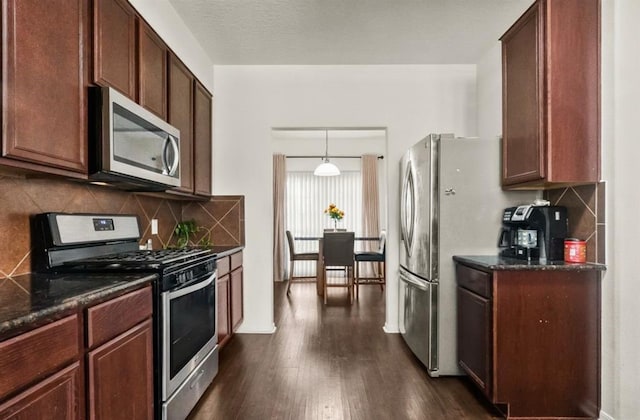 1942 Macondray Dr, Humble, TX 77396 - kitchen featuring hanging light fixtures, appliances with stainless steel finishes, dark wood-style floors, and tasteful backsplash