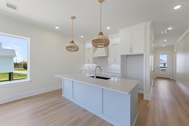 4042 Miramar Ct, Galveston, TX 77554 - kitchen with a sink, light wood-type flooring, white cabinetry, and visible vents