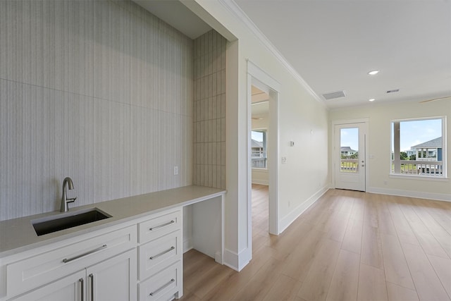 4042 Miramar Ct, Galveston, TX 77554 - interior space with baseboards, ornamental molding, a sink, and light wood-style floors